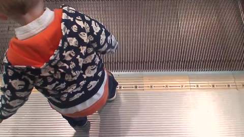 A Tot Boy Makes A Split When He Steps Onto A Moving Sidewalk