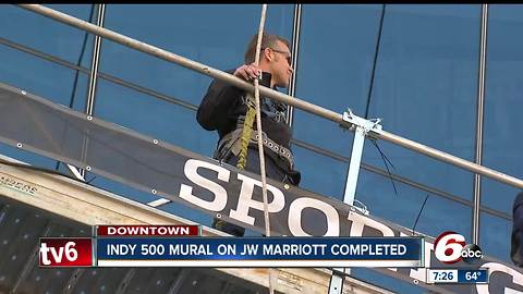 IndyCar driver Ed Carpenter helps put decal on JW Marriott downtown