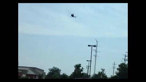 Hughes MD 500 helicopter hovering over Chicago