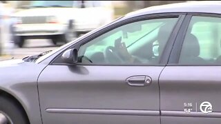 Officials push to outlaw holding cell phone while driving