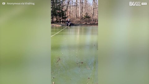 Deux hommes tentent de faire de la luge sur un lac gelé