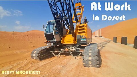 Heavy crane installing wall in desert