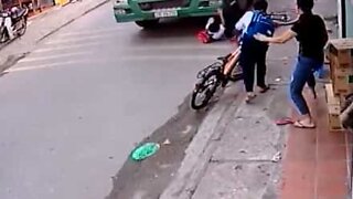 Boy almost gets run over by truck after falling off bike