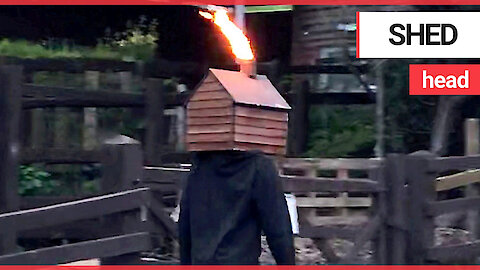 Just a man walking along the street with a flame-throwing shed on his head