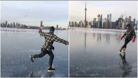 Man åker skridskor på en frusen sjö i Toronto och visar imponerande tricks