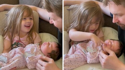 Little Girl Preciously Holds Her Newborn Baby Sister