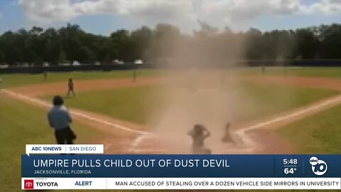 Umpire saves child from dust devil during baseball game