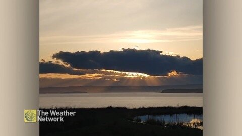 A serene scene as rays of sun peek through the clouds