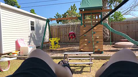 Dad Ties Rope to Son's Swing and Sways him While Sitting Comfortably