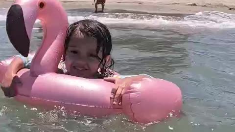 Beach Day Cheeky Riding the Waves on Her Pink Flamingo Floaty