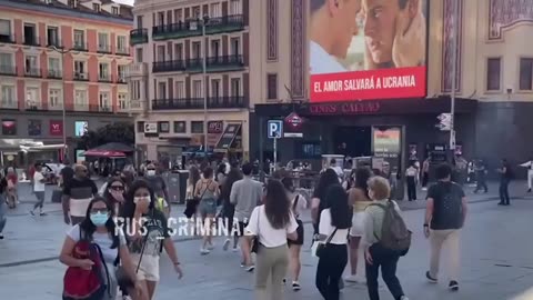 In Spanish Madrid, a street cinema shows a video with two "men" and "Love will save Ukraine