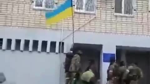 Soldiers of the Ingush riot police remove the Ukrainian flag from the wall