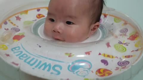 Baby boy swimming in the bathtub.