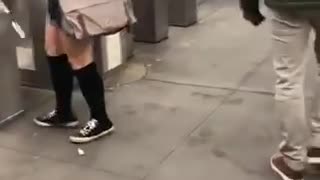 Woman goes through subway turnstiles with a cardboard box on her head