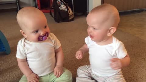 Twin baby girls fight over pacifier