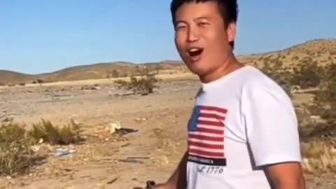 An Asian man, firing his weapon, declares a dark promise to conquer America