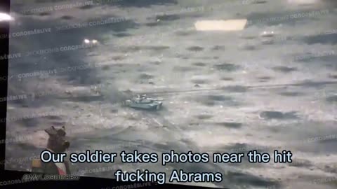 Russian soldier takes a selfie in front of an Abrams tank that has been hit and abandoned