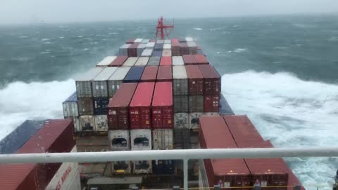 A frightening scene of a container ship wreastling with the waves