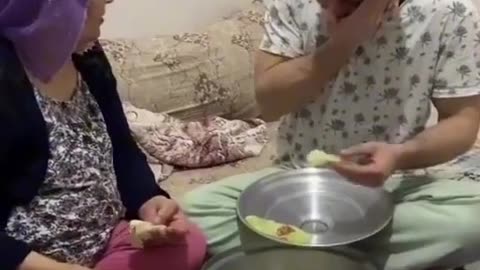 A son prepares food in the style of preparing a weed in front of his mother