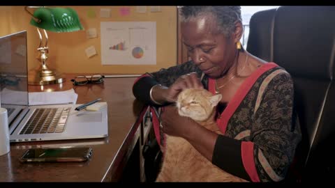 African American woman working at home with a laptop computer and cell phone