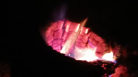 A Wood Stove Burning A Holey Oak Log