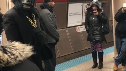 Guy dressed in gorilla tuxedo suit dances in subway station