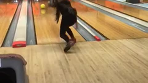 Girl throws bowling ball falls down