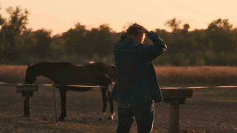 Back view of senior male throwing away straw hat and stretching