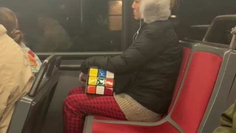 Woman with grey ear muffs and giant rubix cube