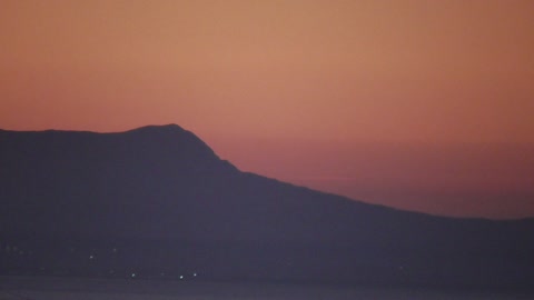 Orange sky. Mountain and sea.