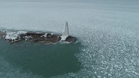 Frozen Waves of Lake Michigan Hit Elevated Catwalk of Light House Amidst Water