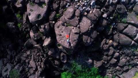 A Couple Lying Down On A Cliff Rock For A Video Shoot