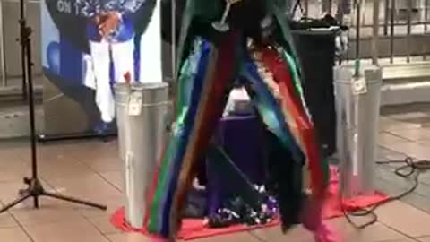 Man in a green blazer dancing and singing in subway