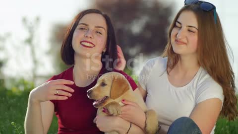 Women playing with puppy