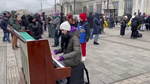 Pianist playing Outside Lviv station, Full of exhausted refugees fleeing war from Russia