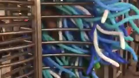 Body suit of blue balloons in subway station