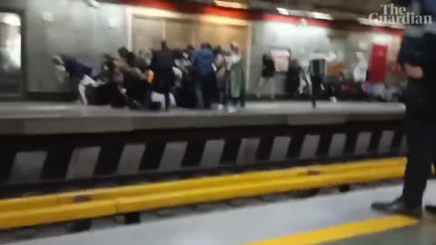 People run for cover as Iranian police open fire during protest at Tehran metro station