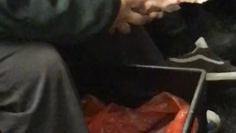 Man eats a cooked pig off the bone on subway train