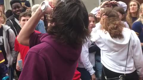 Teen in purple sweatshirt cracks beer over head and chugs it