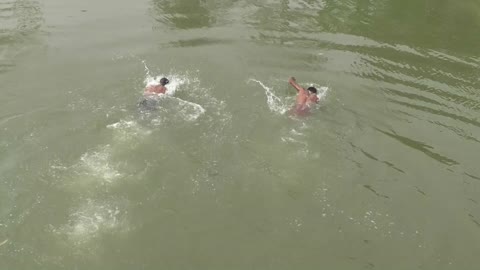 Boys enjoying swimming into a small river in village