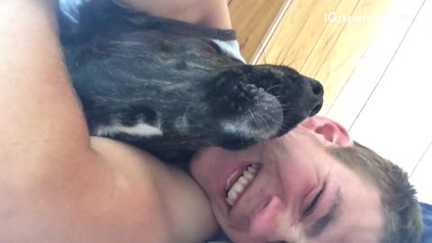 Guy hugging black dog howls and then dog howls as well