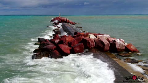 Drone Flys Break Wall As Massive Waves Wash Over It 4K Drone Footage