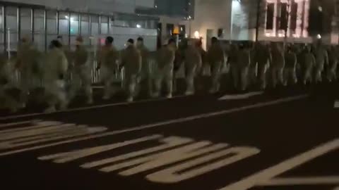 Troops march in front of the US capitol building.