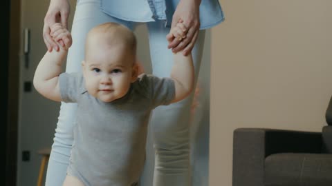 Mom helping toddler to walk