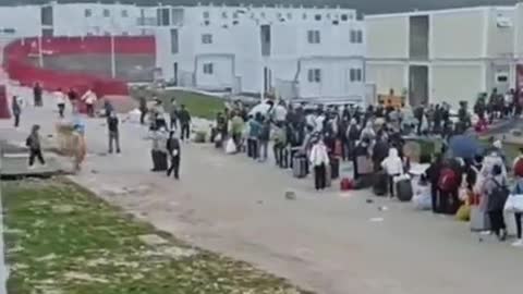 Enorme folla in arrivo in autobus verso un campo di isolamento