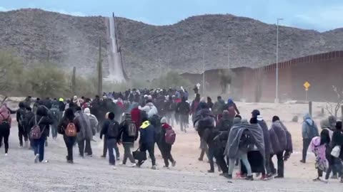 HUNDREDS OF ILLEGAL IMMIGRANTS HERE IN LUKEVILLE, AZ NOW MARCHING TOWARDS AN OUTDOOR PROCESSING AREA