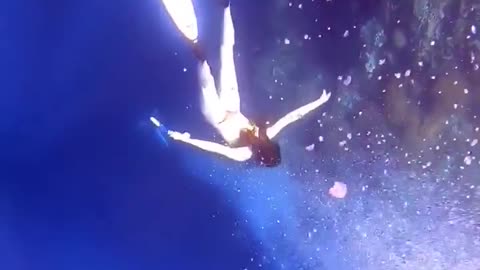 A girl diving under the sea showing beautiful views