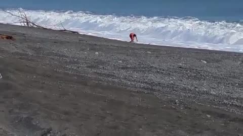 Man with green boogie board knocked down by wave