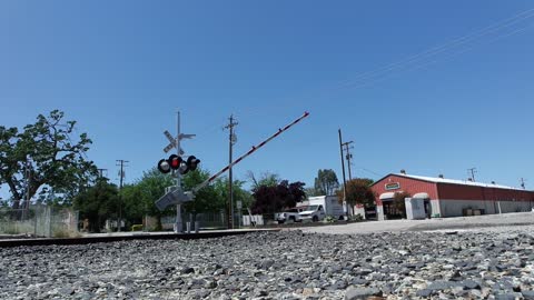 A Train Passing Through A Railroad Crossing