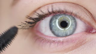 A woman putting on Mascara